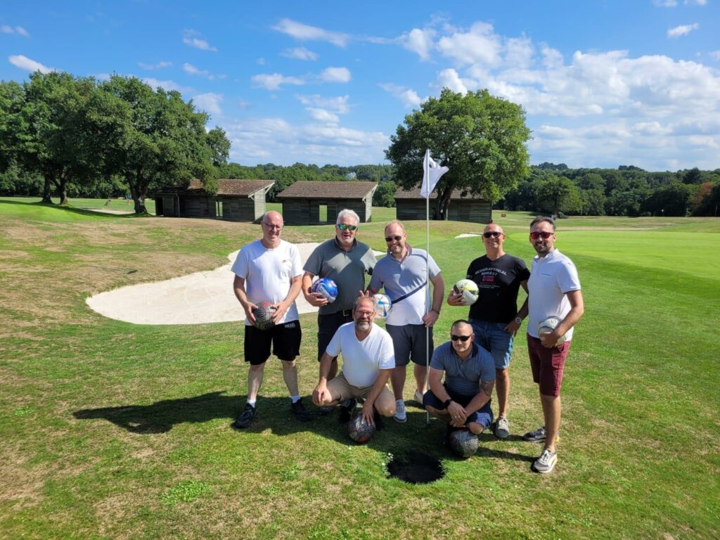 Photo de l’équipe OCEAM lors d’une journée de team building au Foot Golf à Savenay en 2025. Les collaborateurs posent ensemble sur un terrain vert, avec des maillots et des ballons de foot, dans une ambiance détendue et amicale, entourés d’arbres et d’un ciel dégagé.